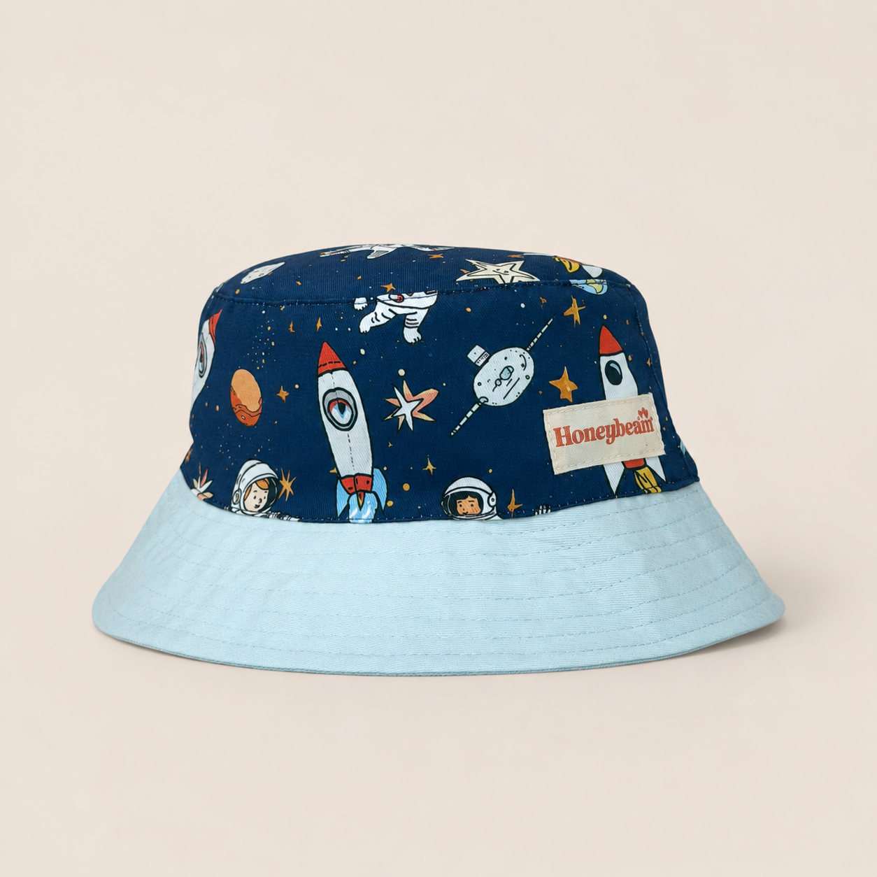 A bucket hat with a navy blue space-themed printed crown and a solid light blue brim, featuring a Honeybeam brand label on the side.